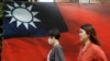 人們從台北街頭的台灣旗幟旁走過。（2020年8月10日）