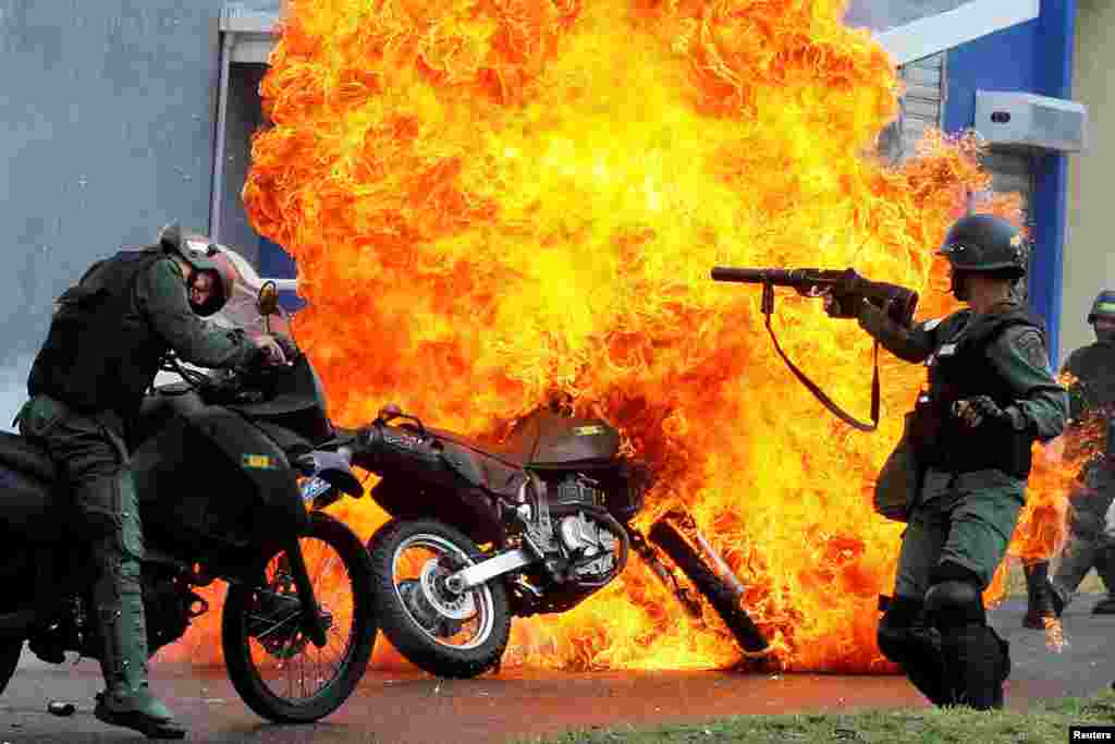 Riot security forces clash with demonstrators as a motorcycle is set on fire during a protest against Venezuelan President Nicolas Maduro's government in San Cristobal, May 29, 2017.