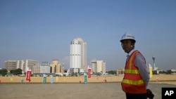 资料照片：一名中国建筑工人站在一带一路工程项目斯里兰卡科伦坡港口城工地上。(2018年1月2日)