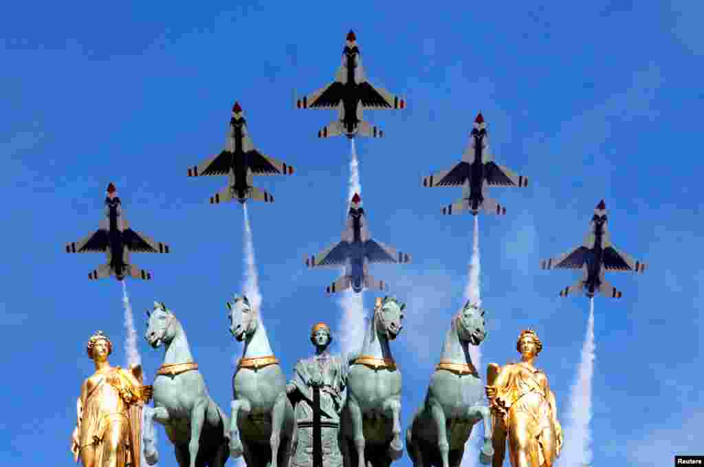 法国国庆节阅兵，美国空军的雷鸟（Thunderbirds）战机飞过巴黎的卡鲁索凯旋门上空（2017年7月14日）。图片显示了巴黎的另一座凯旋门&mdash;&mdash;卡鲁索凯旋门顶部的雕塑。