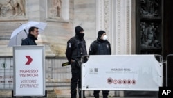 Personnel performing security checks wear face masks as the Duomo reopened to the public after being closed due to the COVID-19 virus outbreak in northern Italy, in Milan, March 2, 2020.