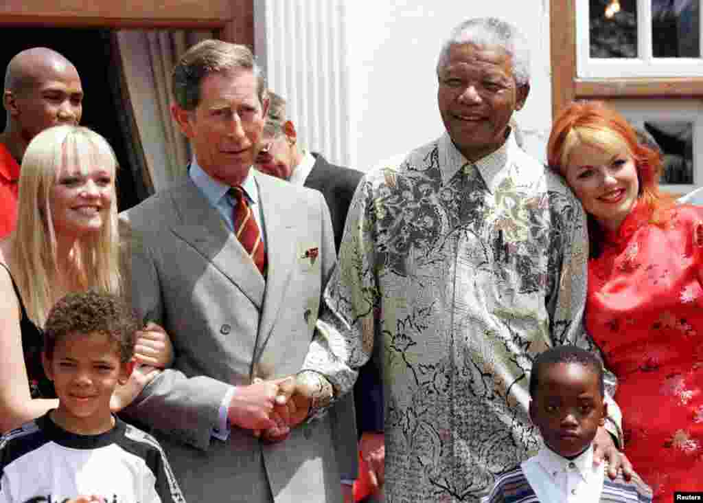 Presiden Nelson Mandela dan Pangeran Charles dari Inggris berjabat tangan didampingi anggota "Spice Girls" Emma (kiri), dan Gerri (kanan) di kediaman Mandela 1 November 1997.