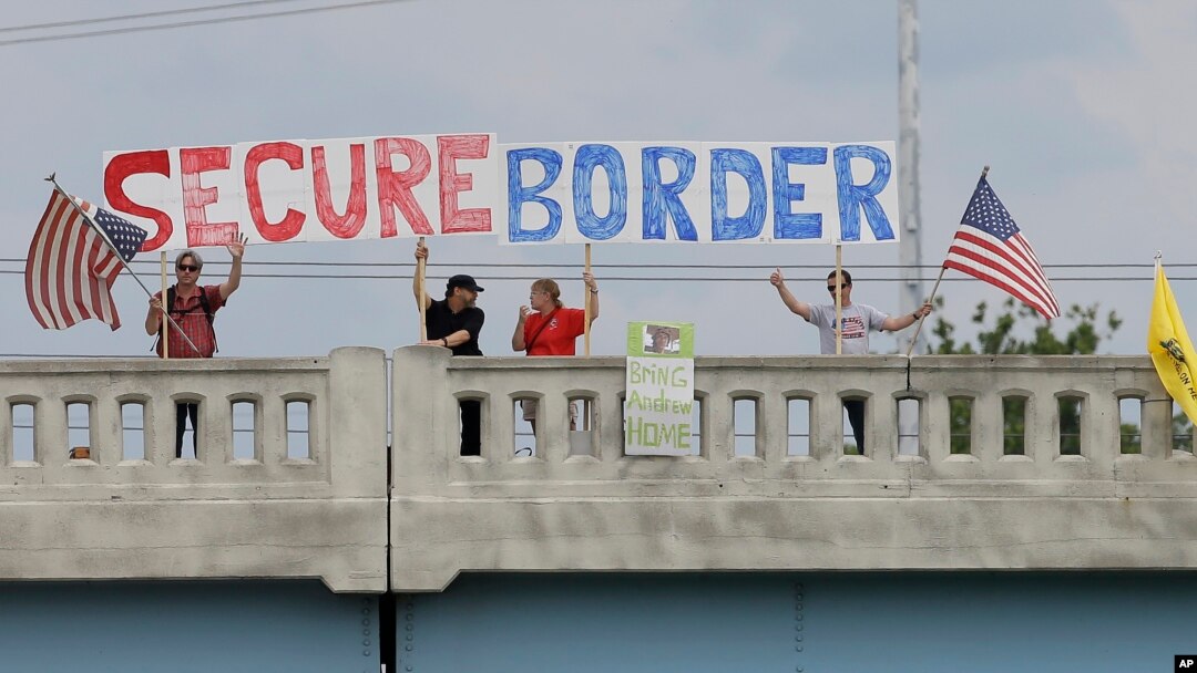 FILE - Demonstrators with signs on an overpass in Indianapolis, Indiana, protest against people who immigrate illegally July 18, 2014.