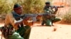 FILE - Kenyan policemen hold their position while patrolling the Kenya-Somalia border near the town of Mandera, Feb. 6, 2015. 