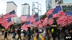 Protesters wave American flags as they march from Chater Garden to the U.S. consulate in Hong Kong, Sept. 8, 2019, to call on the U.S. to pressure Beijing to meet their demands.