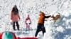 2014年12月6日民众在中国河北省张家口市崇礼县的一处滑雪场与爱犬在雪中嬉戏。