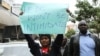 Protesters hold signs like this one, which demands an end to the intimidation of election officials, during a march in Nairobi, Aug. 1, 2017.