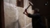 FILE - This image made from video posted on a militant social media account affiliated with the Islamic State group, April 11, 2015, purports to show a militant taking a sledgehammer to an Assyrian relief at the site of the ancient Assyrian city of Nimrud, which dates to the 13th century B.C.