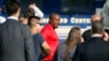 Federal agents hold a detainee, center, in Los Angeles after raids, Aug. 22, 2019. U.S. authorities have an indictment charging 80 people with participating in a conspiracy to steal millions of dollars through fraud schemes and laundering the funds.