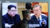 一名韩国士兵在首尔火车站走过正在播放有关朝鲜领导人金正恩和韩国总统文在寅的新闻报道电视图面. (2018年4月18日)