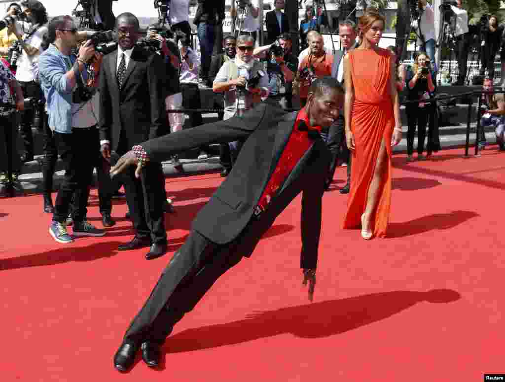 Aktor Souleymane Deme (tengah) melakukan aksi di karpet merah saat tiba bersama sutradara Mahamat-Saleh Haroun (kiri) dan Anais pemeran Monory untuk pemutaran film "Grigris" selama Festival Film Cannes ke-66 di Cannes, Perancis.