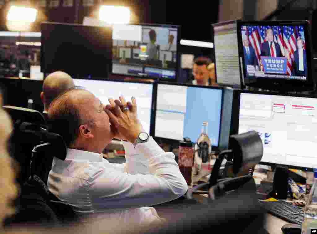 Seorang pialang saham bereaksi sambil menonton Presiden-terpilih Donald Trump memberikan pidato kemenangan pilpres pada layar TV di bursa saham kota Frankfurt, Jerman.