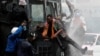 Demonstranti se penju na policijsko vozilo u Najrobiju, 25. jun 2024. (REUTERS/Monicah Mwangi)
