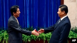 中国国家主席习近平与日本首相安倍晋三在人民大会堂会晤前握手 (2014年11月10日)