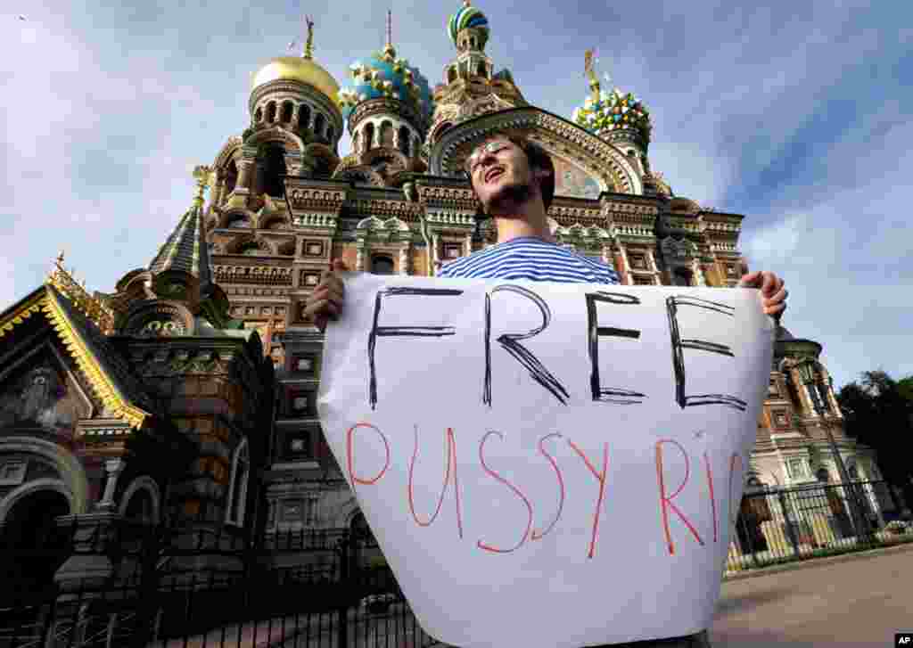 在俄罗斯的圣彼得堡一个大教堂外面,抗议人士拿着呼吁释放“Pussy Riot”歌手的标语