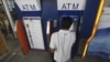 A man uses an automated teller machine (ATM) machine at a shopping center in Yangon, Burma, May 27, 2012.
