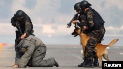 Members of the Turkish police special unit handle a trained dog as they arrest a man during an anti-terror drill as part of a security exercise in western Turkey.