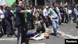 Un hombre herido yace sobre el asfalto en una calle de Bogota. Un atentado provocó la muerte de al menos cinco personas e hirió a unas 19.