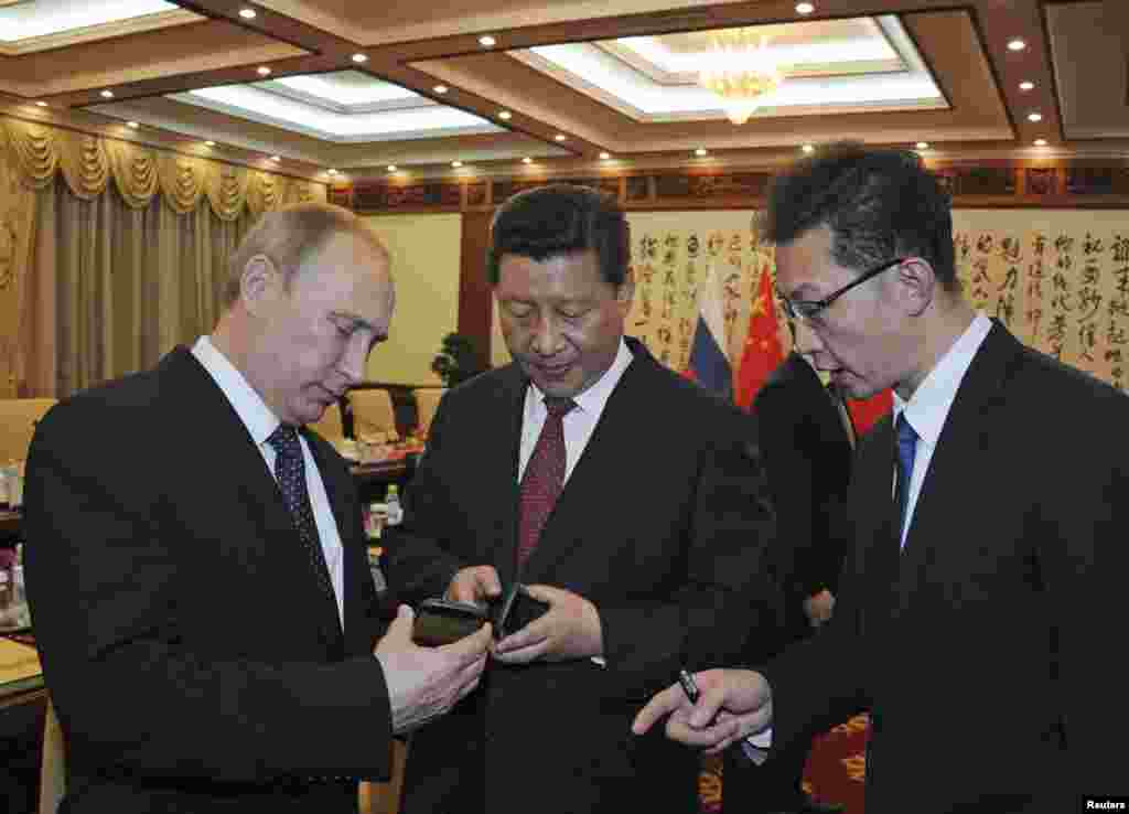2014年11月9日,在北京参加APEC会议的俄罗斯总统普京向中国国家主席习近平介绍俄罗斯生产的智能手机YotaPhone。