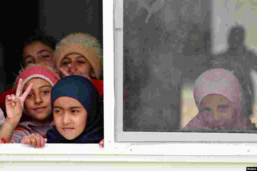 Syrian refugee children look out of their classroom window at Al- Zaatri refugee camp, in the Jordanian city of Mafraq, near the border with Syria, February 12, 2013.