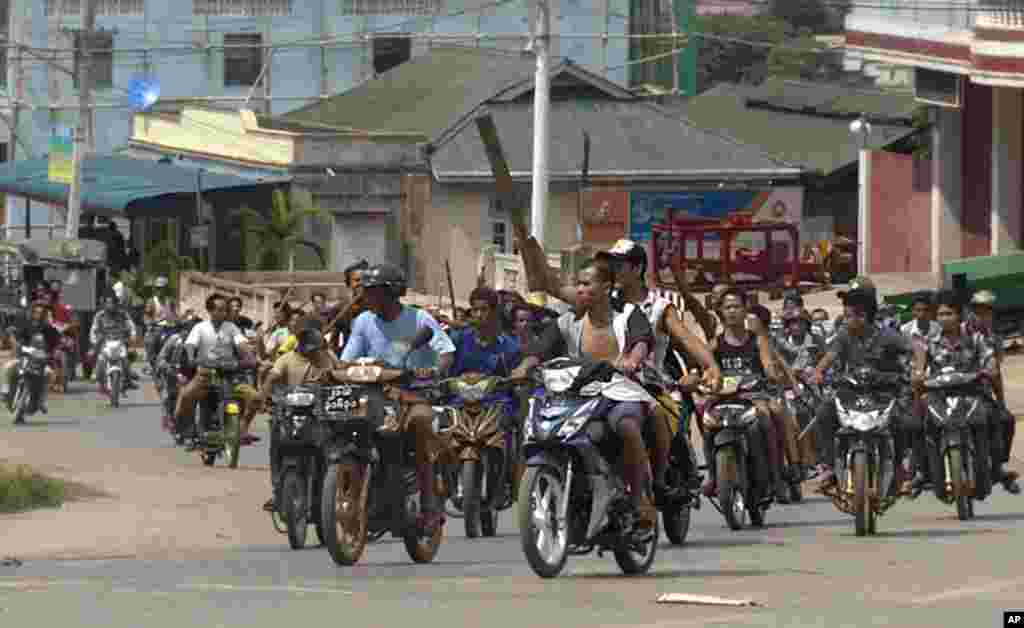 Ratusan pria Buddha mengendarai sepeda motor bersenjatakan tongkat melakukan patroli di jalan-jalan di kota Lashio, negara bagian Shan, Burma di mana kekerasan sektarian dikhawatirkan akan menyebar di sana.