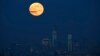 A full moon is seen in the sky behind New York's Lower Manhattan skyline in this June 23, 2013, file photo.
