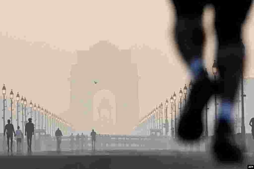 Pedstrians walk near the India gate amid smoggy conditions after Diwali, the Hindu festival of lights, in New Delhi.