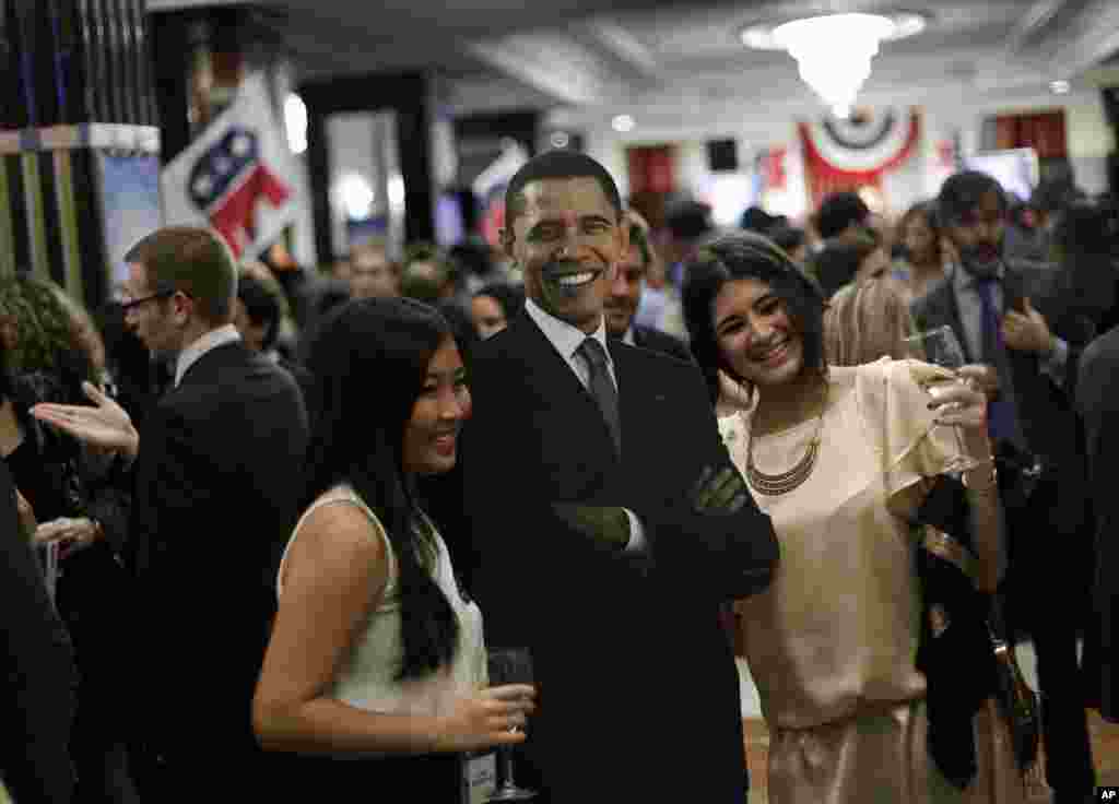 西班牙马德里国际酒店的美国总统选举夜庆祝会上，人们在奥巴马的肖像旁摄影留念。