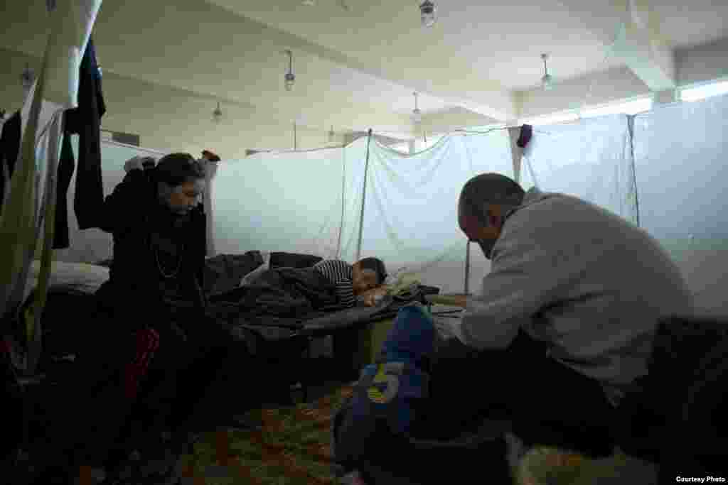 Most of the refugee families live dormitory style, maintaining privacy with curtains of sheets or blankets, in the temporary accommodation center at Voenna Rampa, Sofia. UNHCR/D.Kashavelov
