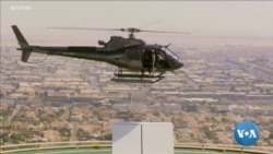 Un cycliste saute d'un hélicoptère sur le toit d'un gratte-ciel de Dubaï