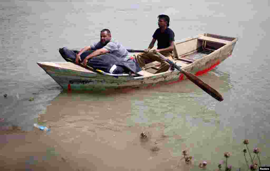 Seorang pria Irak memeluk jenazah istrinya yang meninggal akibat pertempuran di Mosul, menyeberangi sungai Tigris dengan perahu karena jembatan di Mosul barat ditutup.