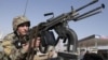 Afghan National army soldier takes on a weapon during a patrol near prayers gather for Eid al-Adha near a mosque in the outskirt of Jalalabad east of Kabul, Afghanistan, Oct. 26, 2012. 