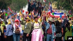 Para demonstran anti-pemerintah meneriakkan yel-yel saat berpawai di jalan-jalan ibukota Bangkok (24/1). Mahkamah Konstitusi Thailand menetapkan bahwa pelaksanaan Pemilu Nasional yang semula dijadwalkan akan diadakan tanggal 2 Februari mendatang dapat ditunda.