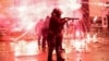 Fireworks shot by protesters explode near police in riot gear firing tear gas during a nationwide protests against the Georgian government's decision to shelve EU membership talks, in Tbilisi, Dec. 2, 2024.