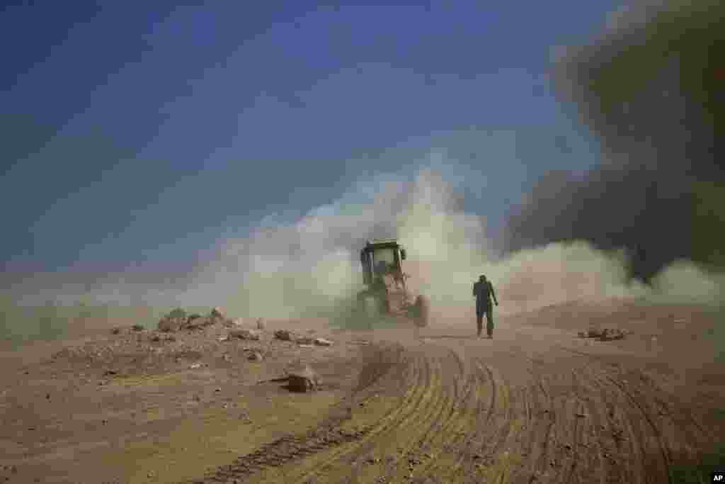 Seorang kontraktor militer Irak keluar dari kendaraannya yang menabrak bom pinggir jalan di Qayyarah, Irak.