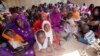 Women and children wait to participate in a vaccination campaign against meningitis at the community center in Al Neem camp for Internally Displaced People in El Daein, East Darfur, Sudan, October 8, 2012.
