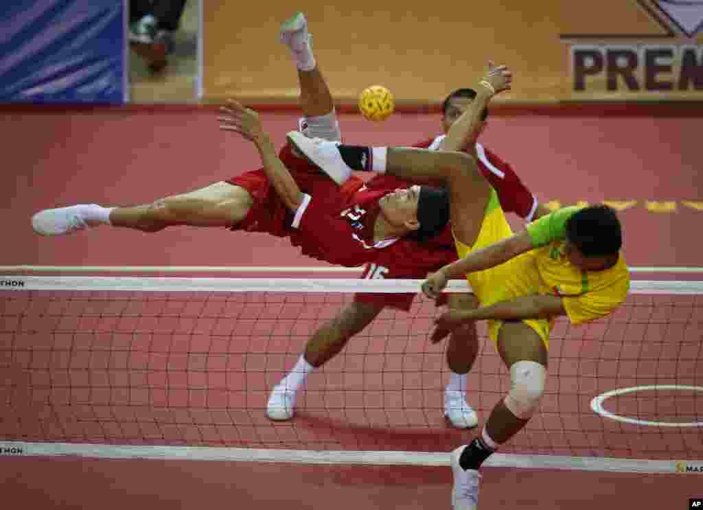 Atlet Thailand Supachai Maneenat, kiri, mengembalikan pukulan takraw dari pemain Myanmar Aung Pyah Tun, kanan, dalam pertandingan sepak takraw SEA Games di Naypyitaw, Myanmar.