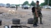 FILE - Police officers stand next to a checkpoint near the site of a Wednesday's blast in Kaduna, Nigeria, July 24, 2014.