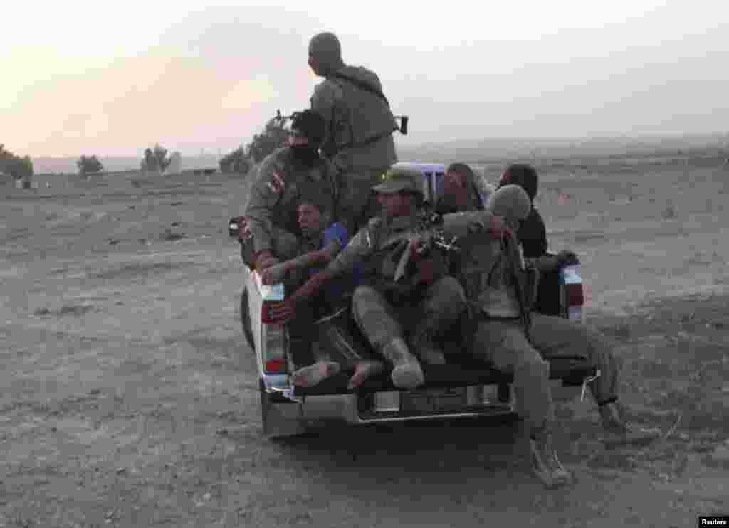 Kurdish peshmerga troops transport wounded men after clashes with militants in Jalawla, Diyala province, Iraq, July 4, 2014.