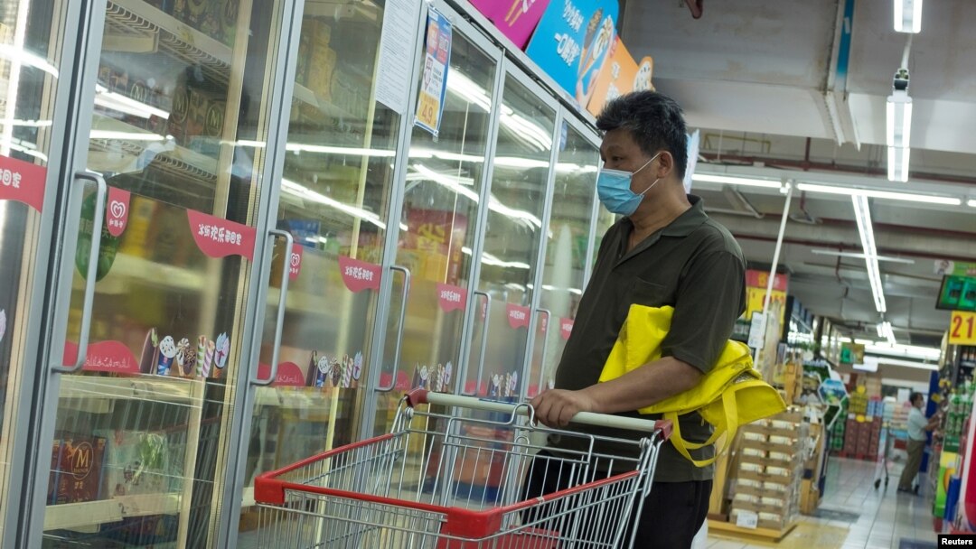 一名男子戴口罩在超市選購冷凍食品。（2020年8月13日）