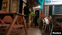 Armed men are seen near a door of a hotel in Sabah, April 2, 2014.