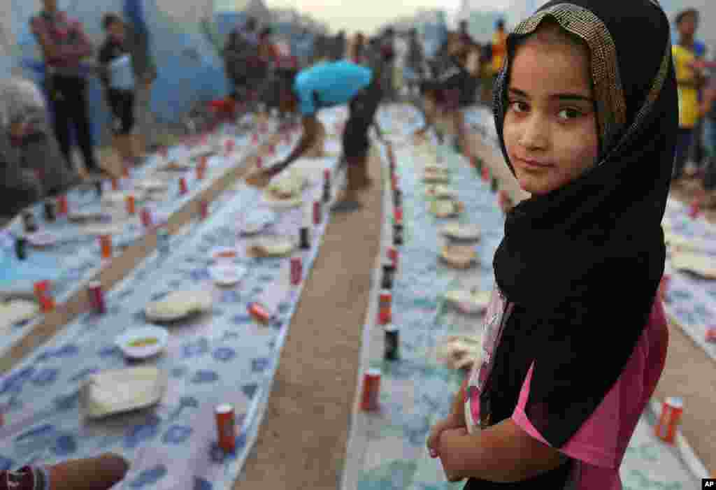 Seorang anak pengungsi Irak menanti saat berbuka puasa bersama di kamp pengungsi di Khazer, di luar Irbil, Irak utara (29/6). (AP/Hussein Malla)