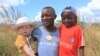 FILE - Razik Jaffalie carrys his two sons in this Monday, May, 23, 2016 photo in Machinga, north east of Blantyre, Malawi. He had to give up his job to protect them. Since 2013, 26 Malawian albinos have been killed and 130 injured.
